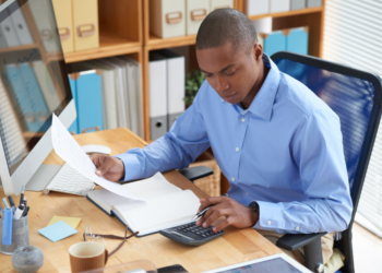 Imagem de um homem fazendo contas em seu escritório